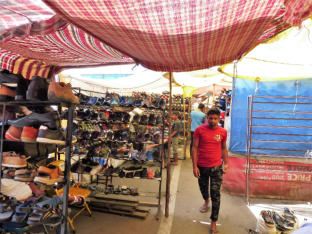 Man walking by Juna Bazaar Shop Selling Shoes